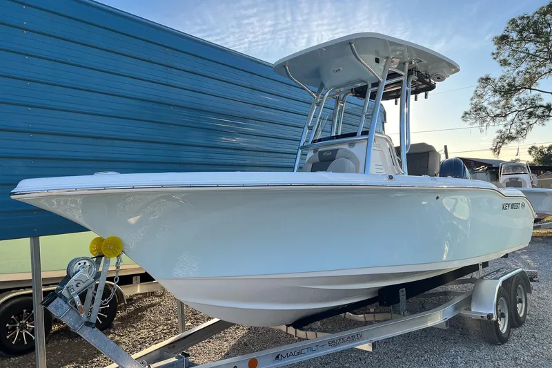 The Image of 2026 Key West 219 FS boat on trailer, parked outdoors near blue building. - 1