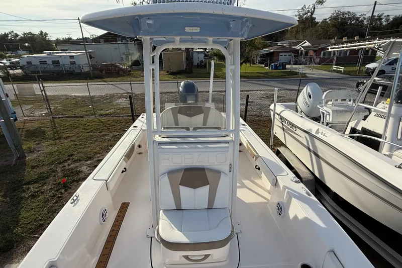 Slide: The Image of 2023 Robalo 226 Cayman boat with center console and seating, parked outdoors. - 12