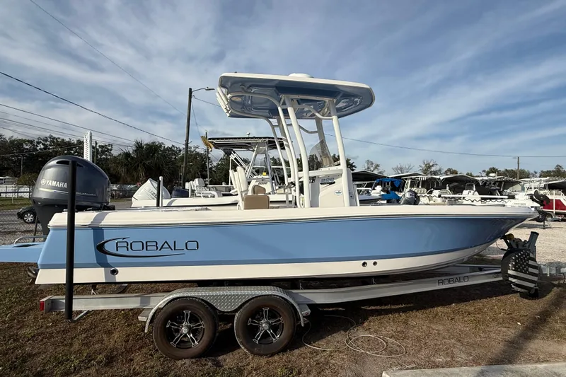 Slide: The Image of 2023 Robalo 226 Cayman boat on trailer, featuring Yamaha engine, blue and white design. - 3