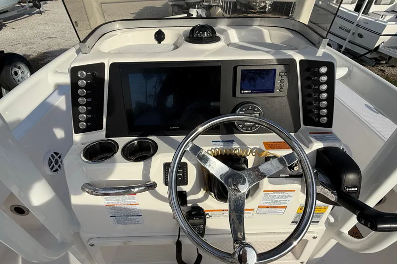 Slide: The Image of 2023 Robalo 226 Cayman boat dashboard with steering wheel and control panel. - 7