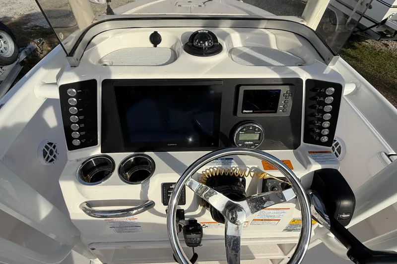 Slide: The Image of 2023 Robalo 226 Cayman boat dashboard with steering wheel and navigation controls. - 8
