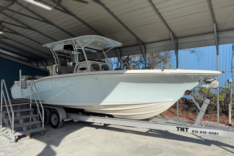The Image of 2025 Key West 291 FS boat on trailer under a metal canopy. - 0