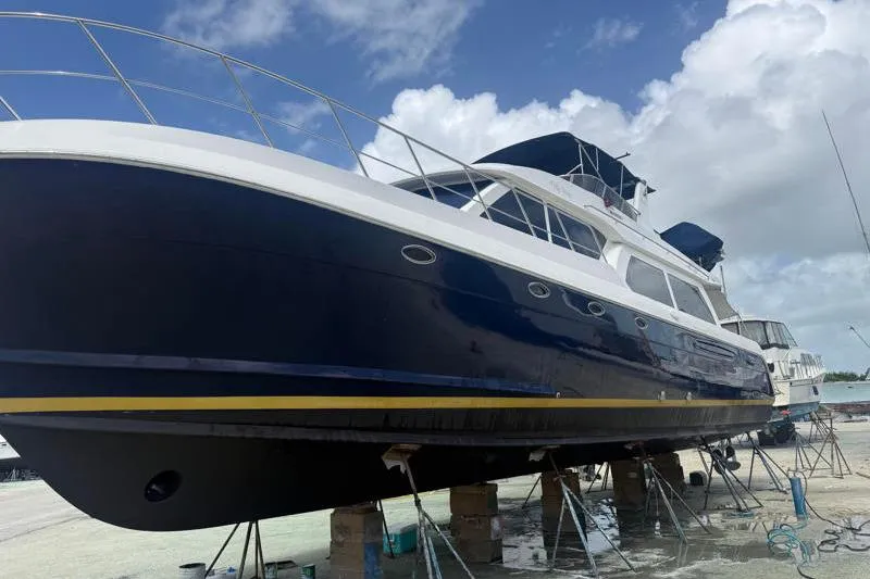 Slide: The Image of 2006 Navigator 5400 yacht on dry dock, blue hull, sunny day, cloudy sky. - 37