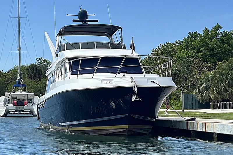 Slide: The Image of 2006 Navigator 5400 yacht docked by lush greenery and clear blue sky. - 43