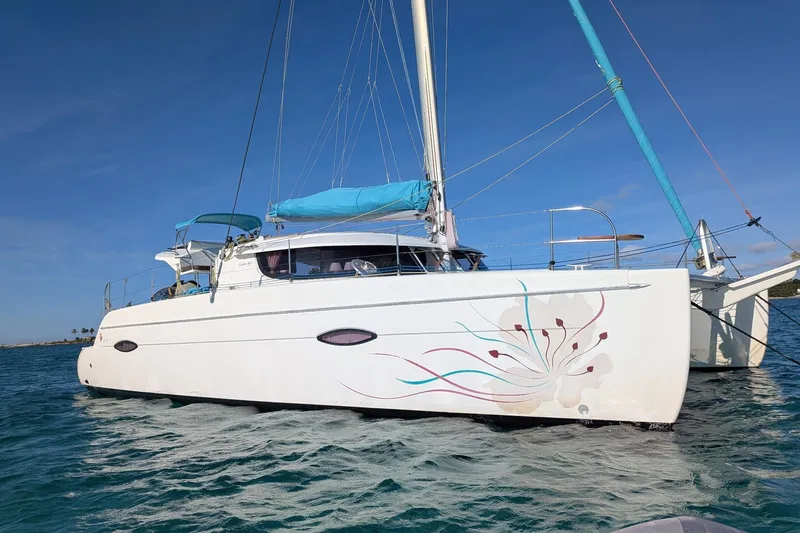The Image of 2012 Fountaine Pajot Lipari catamaran with decorative hull design on calm water. - 0