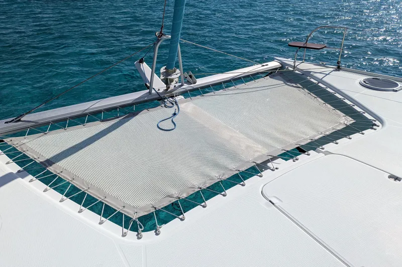 Slide: The Image of 2012 Fountaine Pajot Lipari catamaran deck with netting over clear blue water. - 15