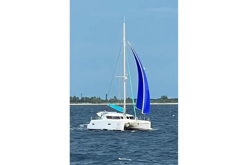 Slide: The Image of 2012 Fountaine Pajot Lipari catamaran sailing on open water with blue sail. - 6