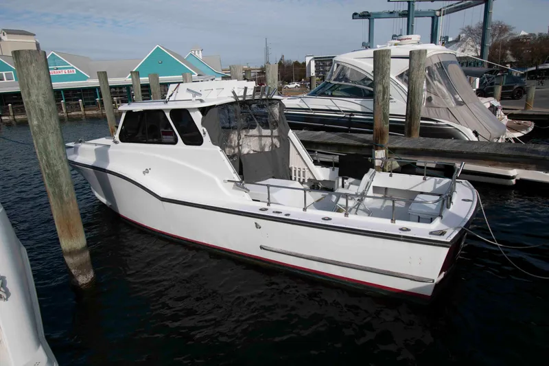 The Image of White 1998 Stan Haven 30 boat docked at marina with blue building in background. - 0