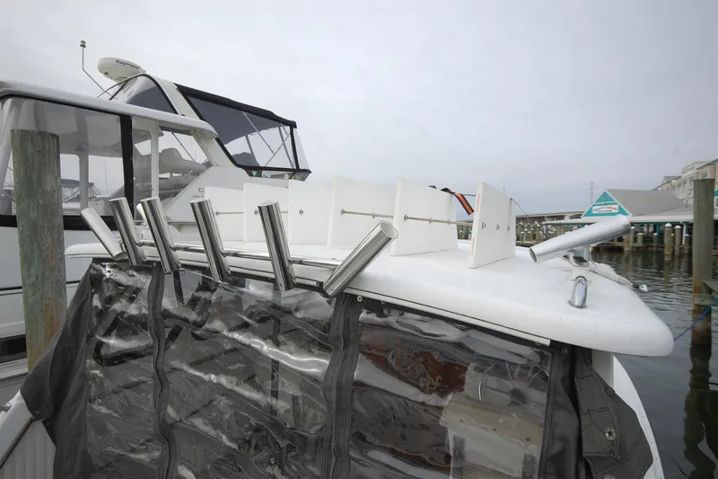 Slide: The Image of Custom Stan Haven 30 boat, 1998 model, docked with fishing rod holders and clear cover. - 4