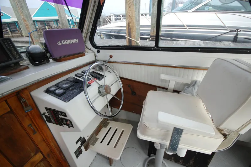 Slide: The Image of Interior of 1998 Custom Stan Haven 30 boat with steering wheel and Garmin device. - 6