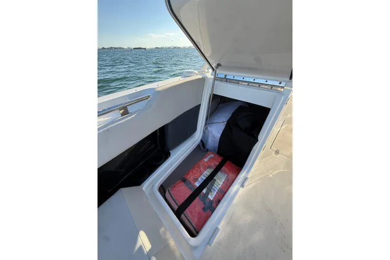 Slide: The Image of Open storage compartment on 2020 Boston Whaler 270 Vantage boat, with life jackets and gear. - 14