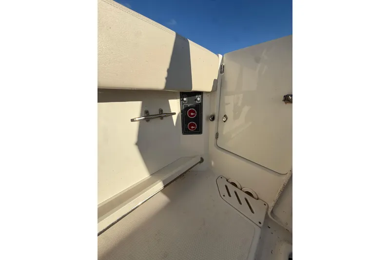 Slide: The Image of 2020 Boston Whaler 270 Vantage interior detail with control panel and storage compartment. - 17