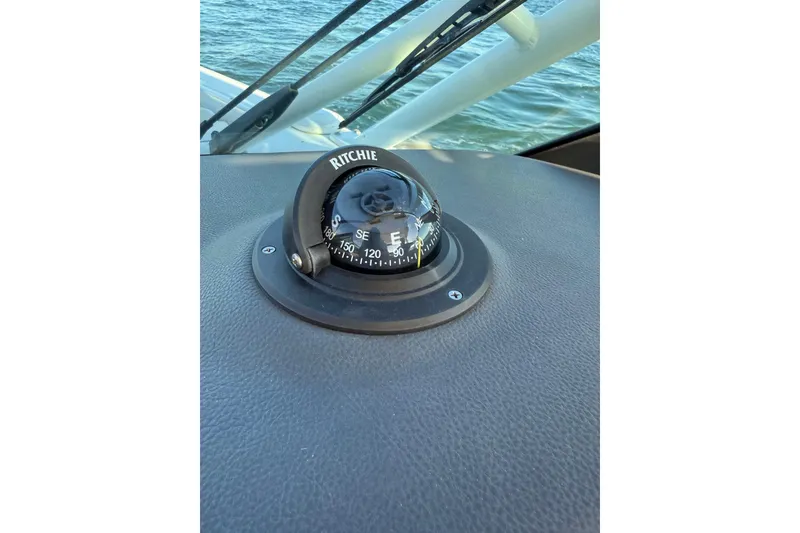 Slide: The Image of Compass on 2020 Boston Whaler 270 Vantage dashboard, overlooking water. - 27