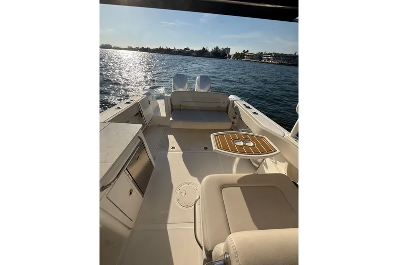 Slide: The Image of 2020 Boston Whaler 270 Vantage boat interior with seating and table on water. - 8