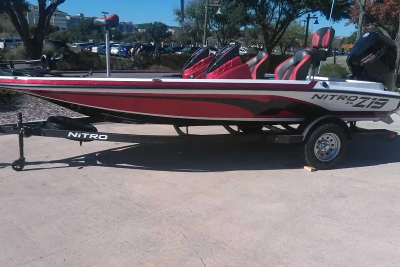 The Image of 2026 Nitro Z19 XL boat in red and black, parked on a trailer outdoors. - 0