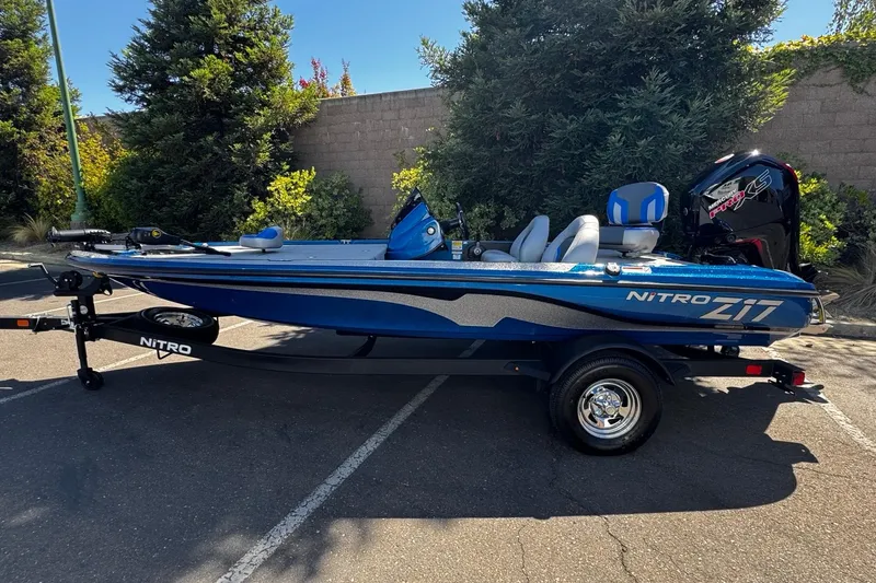 The Image of 2026 Nitro Z17 blue fishing boat parked outdoors on a trailer. - 0