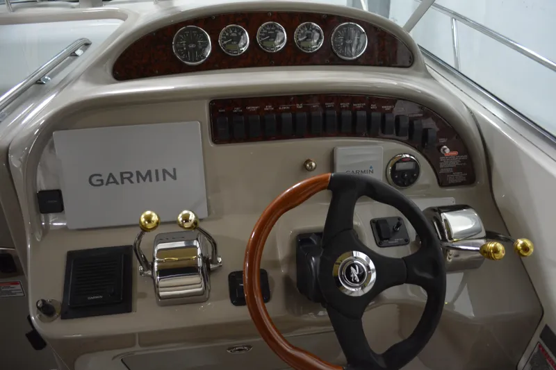 Slide: The Image of 2006 Sea Ray 290 Amberjack helm with Garmin navigation and classic wood-accented steering wheel. - 12