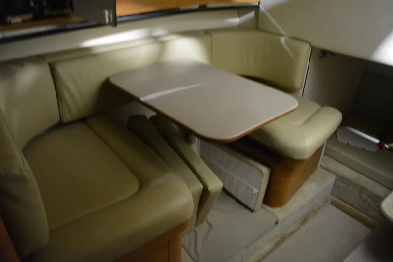 Slide: The Image of 2006 Sea Ray 290 Amberjack cabin interior with beige seating and dining table. - 21