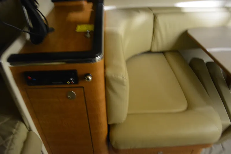 Slide: The Image of Interior of 2006 Sea Ray 290 Amberjack with beige seating and wooden cabinetry. - 29