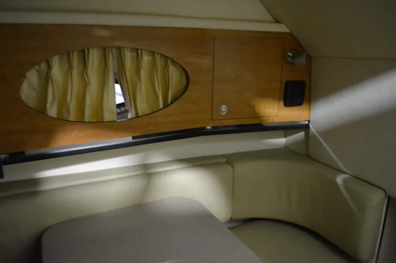 Slide: The Image of 2006 Sea Ray 290 Amberjack cabin interior with wood paneling and seating area. - 31