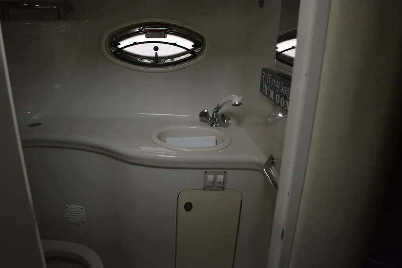 Slide: The Image of 2006 Sea Ray 290 Amberjack bathroom interior with sink and porthole window. - 32