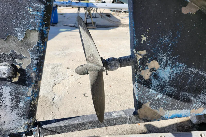 Slide: The Image of Propeller of 1987 Gilbert Caroff Exploration boat with worn paint and visible rust. - 14