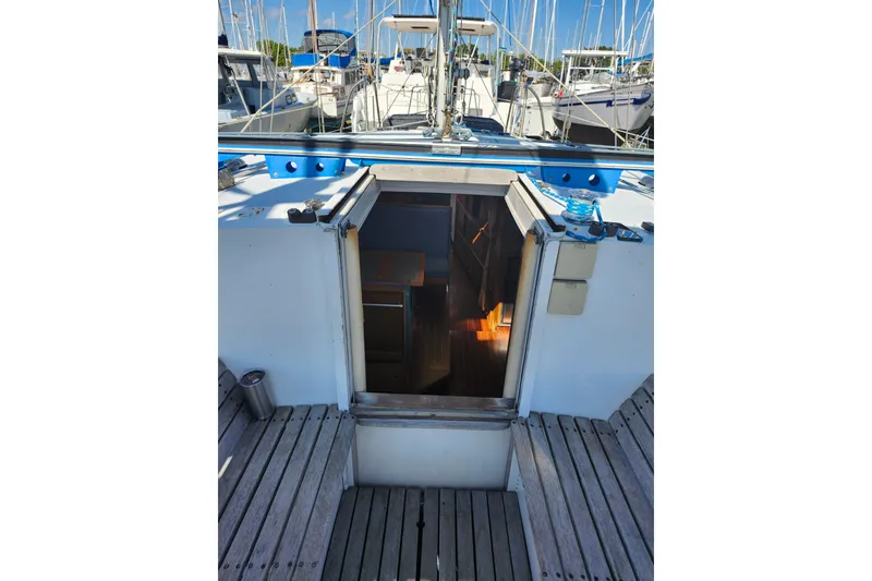 Slide: The Image of Sailboat interior view, Gilbert Caroff Exploration 1987, docked with visible cabin entrance. - 18