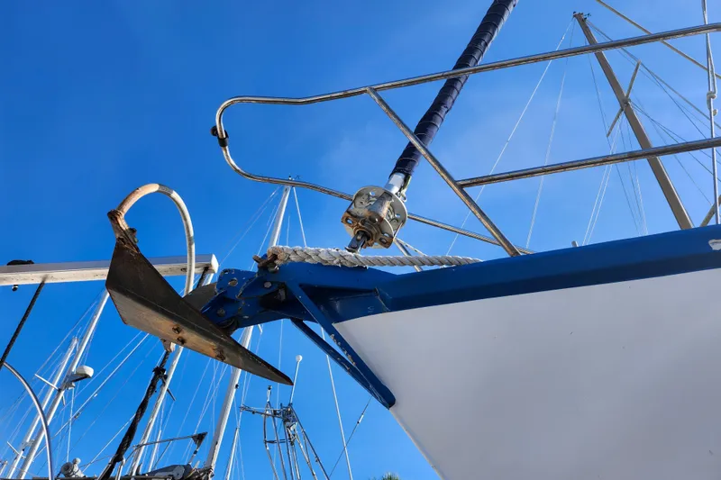 Slide: The Image of Bow of 1987 Gilbert Caroff Exploration sailboat with anchor, under clear blue sky. - 5