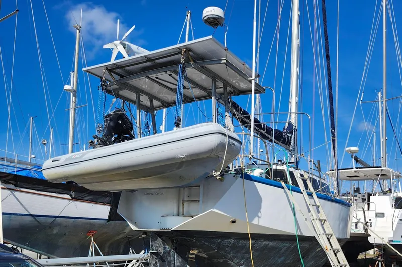 Slide: The Image of Sailboats in a marina, featuring a 1987 Gilbert Caroff Exploration model on land. - 6