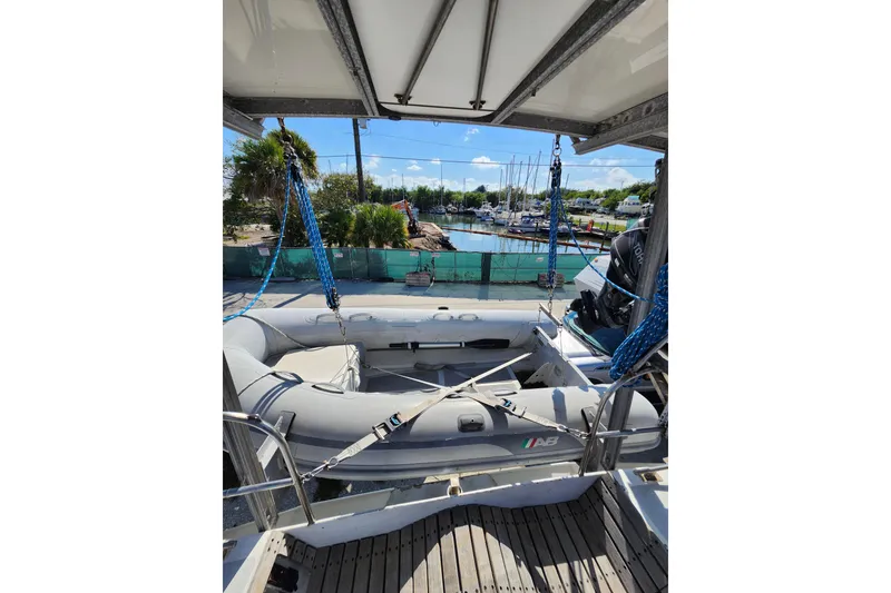 Slide: The Image of 1987 Gilbert Caroff Exploration yacht with inflatable boat on deck, docked at marina. - 8