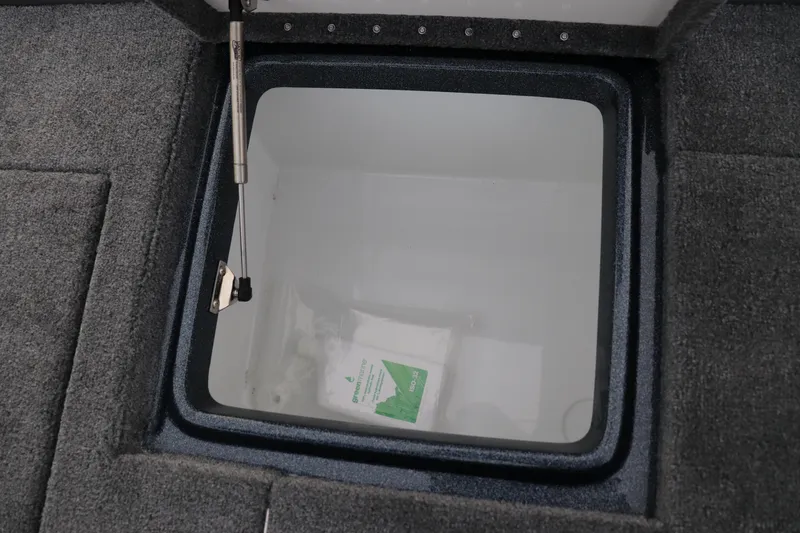 Slide: The Image of Open storage compartment in 2026 Phoenix 721 ZXL boat, featuring carpeted interior. - 13