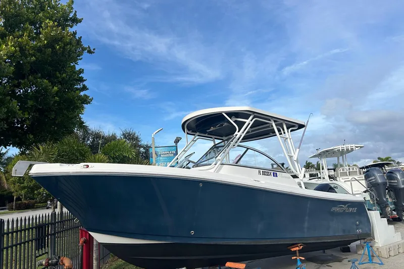 Slide: The Image of 2018 Pro-Line 23 Dual Console boat displayed outdoors on a sunny day. - 0