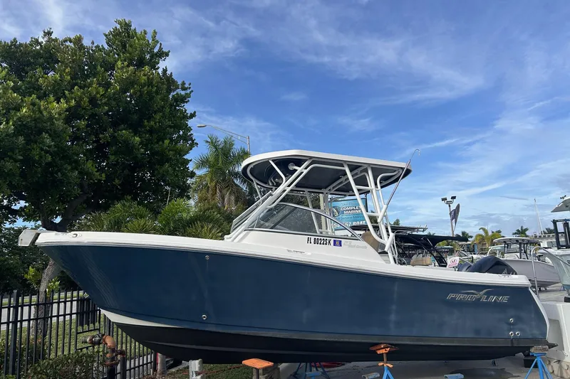 Slide: The Image of 2018 Pro-Line 23 Dual Console boat on display, blue hull, clear sky background. - 1