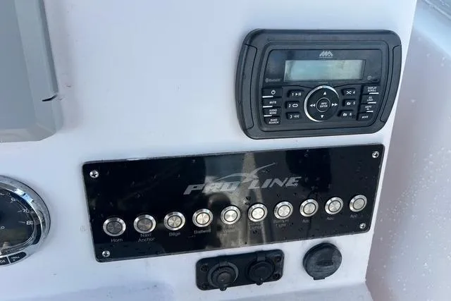 Slide: The Image of Control panel of a 2018 Pro-Line 23 Dual Console boat with radio and switches. - 11