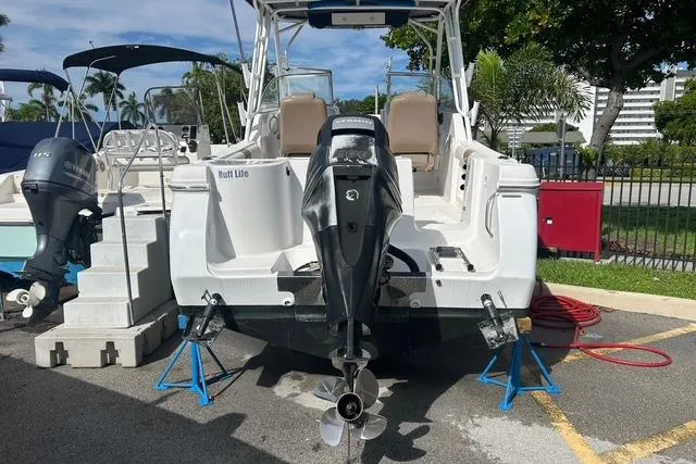 Slide: The Image of 2018 Pro-Line 23 Dual Console boat on stands, rear view with outboard motor. - 2