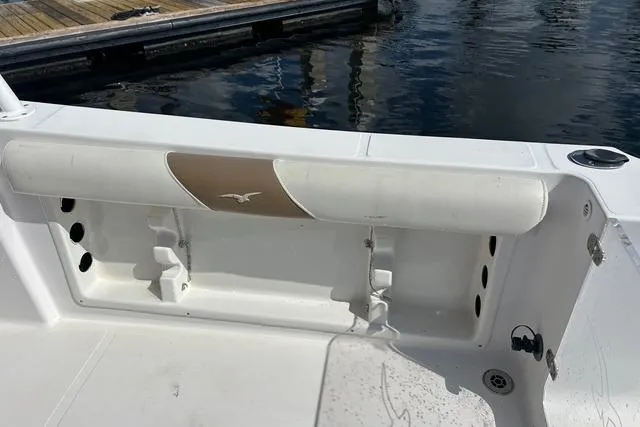 Slide: The Image of 2018 Pro-Line 23 Dual Console boat interior with seating and storage, docked by the water. - 27