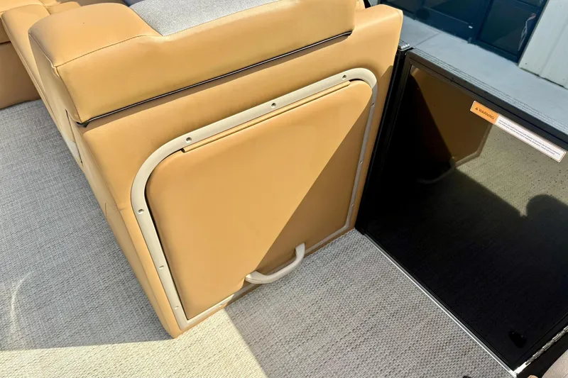 Slide: The Image of 2026 Crest Conquest SE 200 Fish boat interior with tan seating and storage compartment. - 17