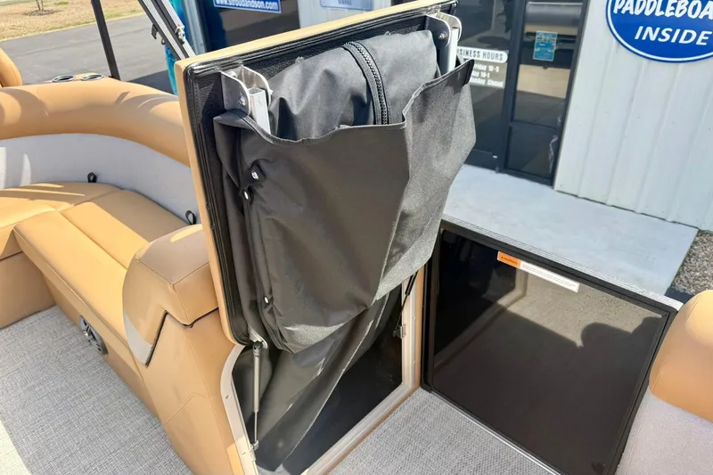 Slide: The Image of 2026 Crest Conquest SE 200 Fish boat interior with storage compartment open. - 18