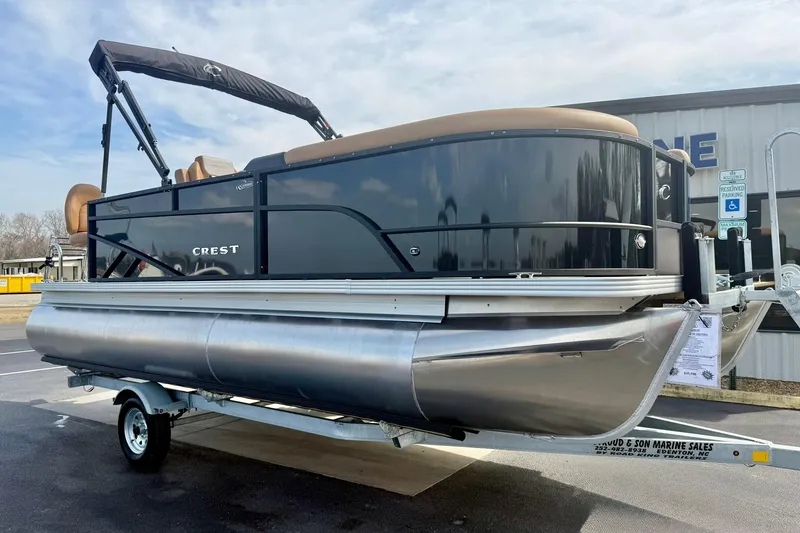 The Image of 2026 Crest Conquest SE 200 Fish pontoon boat on trailer, outdoor display. - 2