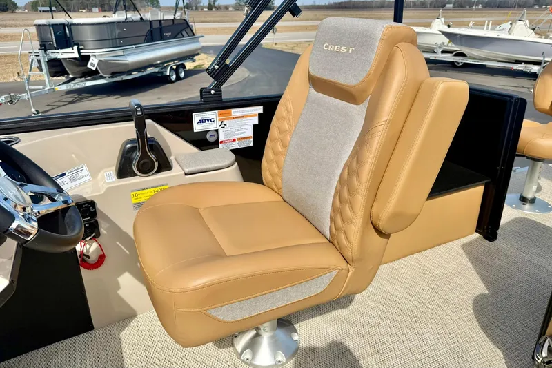 Slide: The Image of 2026 Crest Conquest SE 200 Fish boat interior with tan captain's chair and control panel. - 23