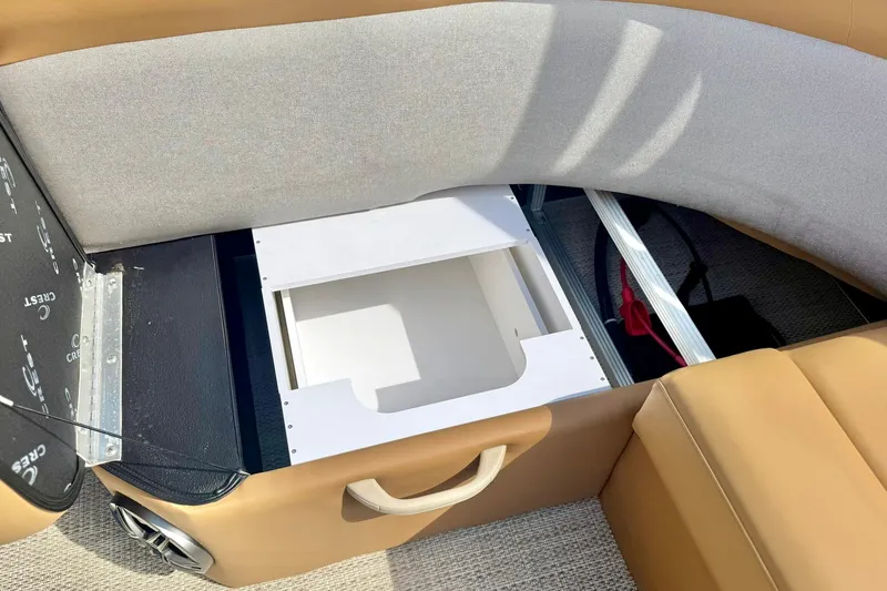 Slide: The Image of 2026 Crest Conquest SE 200 Fish boat interior storage compartment with tan seating. - 28