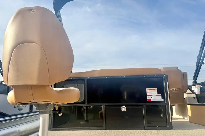 Slide: The Image of 2026 Crest Conquest SE 200 Fish boat interior with tan seating and storage compartments. - 32