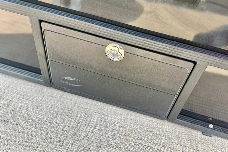 Slide: The Image of 2026 Crest Conquest SE 200 Fish storage compartment with lock, featuring sleek design. - 37