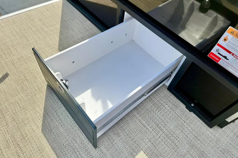Slide: The Image of Open storage drawer on 2026 Crest Conquest SE 200 Fish boat, showcasing interior space. - 38