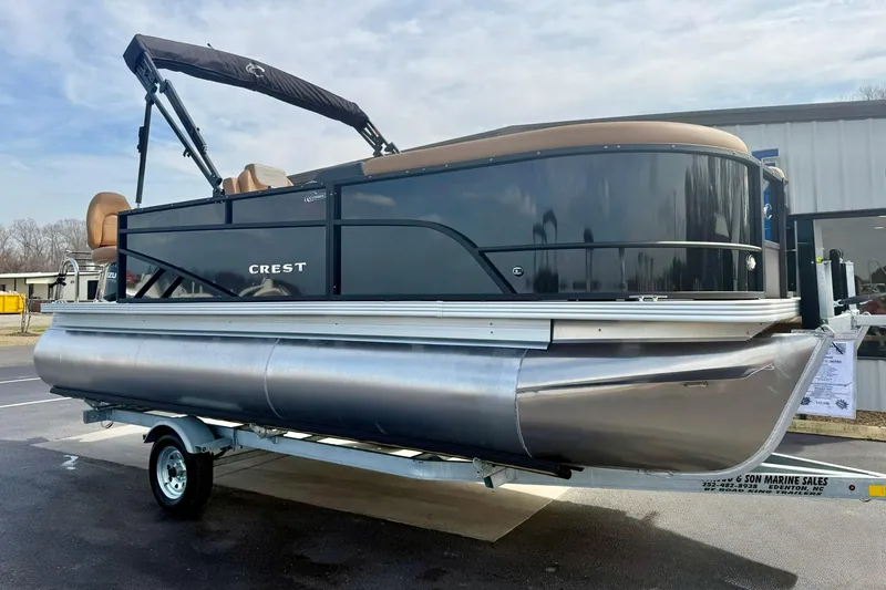 Slide: The Image of 2026 Crest Conquest SE 200 Fish pontoon boat on trailer, black and silver design. - 5