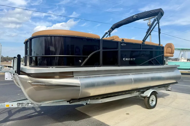 Slide: The Image of 2026 Crest Conquest SE 200 Fish pontoon boat on trailer, black and tan design. - 6