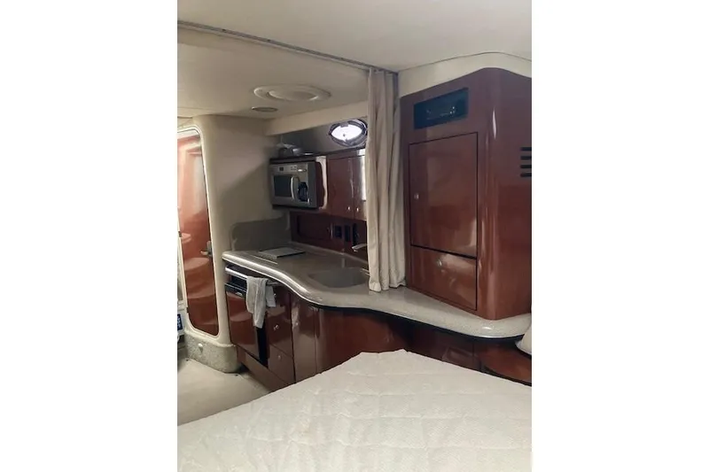 Slide: The Image of 2007 Sea Ray 320 Sundancer cabin interior with kitchenette and wood cabinetry. - 13