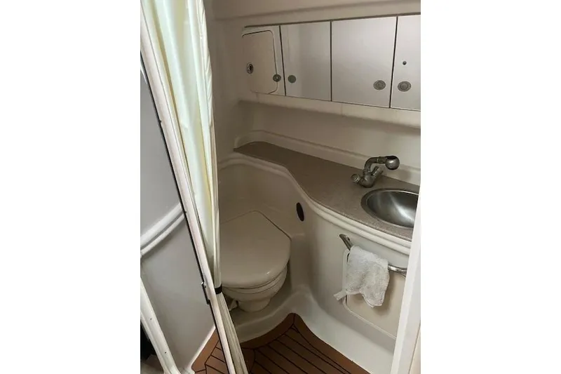 Slide: The Image of 2007 Sea Ray 320 Sundancer bathroom with sink, toilet, and storage cabinets. - 14
