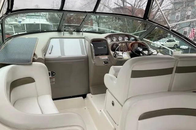 Slide: The Image of Interior view of 2007 Sea Ray 320 Sundancer boat cockpit with white seating and control panel. - 5