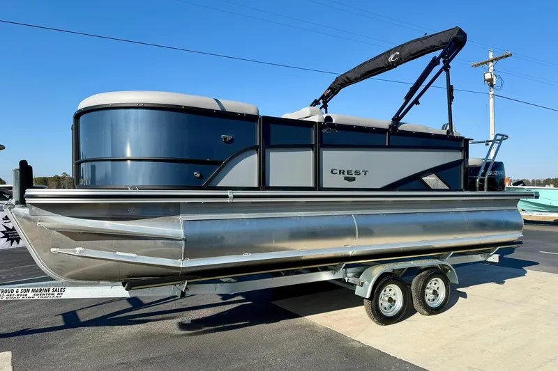 Slide: The Image of 2026 Crest Conquest 210 Fish pontoon boat on trailer, displayed outdoors. - 10